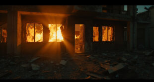 Damaged concrete building with shattered windows and debris scattered on ground in dark urban setting