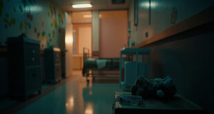 Empty pediatric hospital room with small bed, cheerful wall decorations, and medical equipment in soft lighting