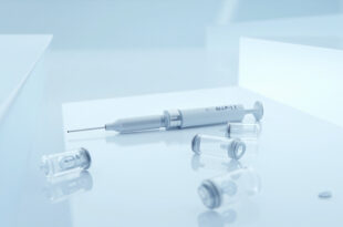 GLP-1 injection pen and medication vials arranged on white clinical surface with soft lighting