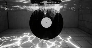 Black vinyl record floating underwater in blue swimming pool with sunlight filtering through water creating ripple patterns
