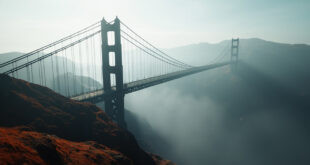 Massive concrete bridge towers stretching across deep mountain canyon with misty gorge below