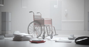 Empty wheelchair next to scattered budget documents and calculator on government desk