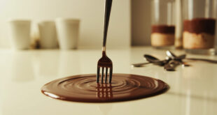 Silver fork piercing smooth chocolate pudding in white cup, creating concentric ripples on surface