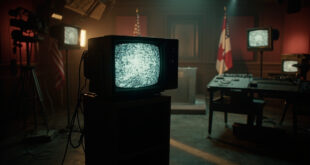 Vintage television set with antennas in broadcast studio, flags draped over empty podium, control panels in background