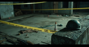Tactical helmet and equipment on concrete barrier with yellow warning tape in empty training area