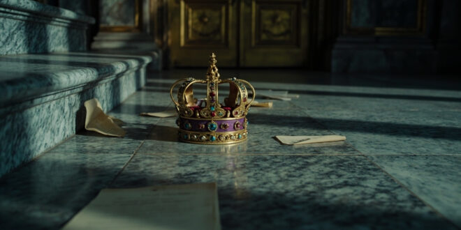 Ornate golden crown lying on marble palace steps with closed doors in background
