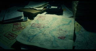Topographic military maps with classification markings spread across a tactical command table in low light