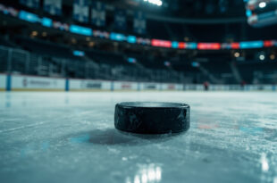 Hockey puck on ice surface in empty championship arena with dramatic lighting