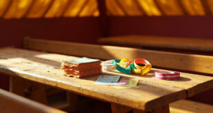 Colorful festival vouchers and admission wristbands scattered on wooden table in empty traditional German beer tent