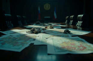 Topographic maps and scattered documents on dark wooden conference table in empty government meeting room