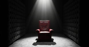 Empty red leather chair in padded diary room under harsh spotlight with dark vignette edges