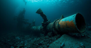 Ruptured undersea pipeline with torn metal edges surrounded by dark ocean water and scattered industrial debris