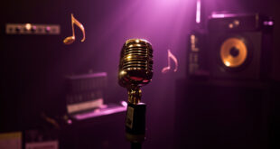 Golden microphone on stand in moody purple-lit recording studio with sparkling light effects around it