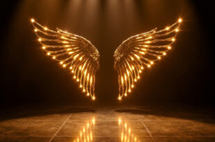 Golden angel wings with glowing bulbs on illuminated fashion runway with dramatic spotlights and reflective floor