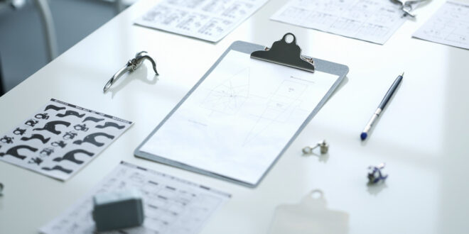 Medical cognitive test forms with animal icons and geometric patterns on clinical examination table under overhead light