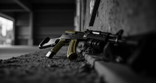 Military rifle and training equipment positioned on concrete ground in urban setting