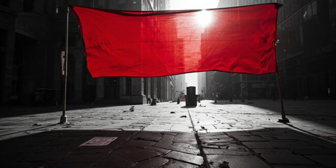 Red protest banner stretched across empty urban plaza with modern buildings under overcast sky