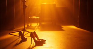 High heeled shoes next to vintage microphone in retro television studio setting with warm amber lighting