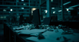 Empty federal office with papers on desk, dark computer screen, chair pushed back, representing government shutdown