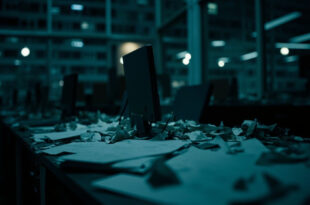 Empty federal office with papers on desk, dark computer screen, chair pushed back, representing government shutdown