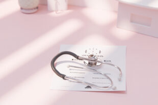 Stethoscope on medical documents with warning icons, surrounded by diagnostic equipment in clinical setting