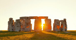 Stonehenge megalith with faint orange powder stains on weathered gray stone surface in daylight