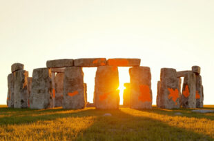 Stonehenge megalith with faint orange powder stains on weathered gray stone surface in daylight
