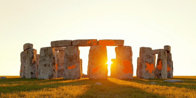 Stonehenge megalith with faint orange powder stains on weathered gray stone surface in daylight